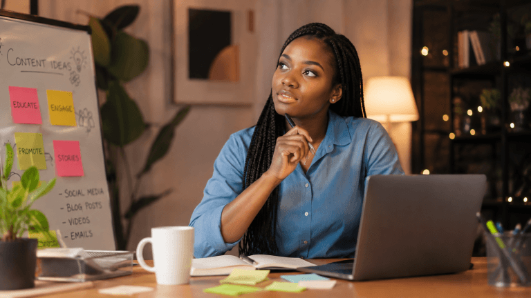 A lady in a work space thinking